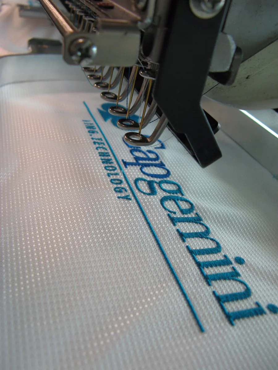 Máquina de bordado computadorizado aplicando logotipo em tecido