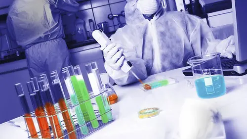 Profissional em ambiente laboratorial com vestimenta de proteção