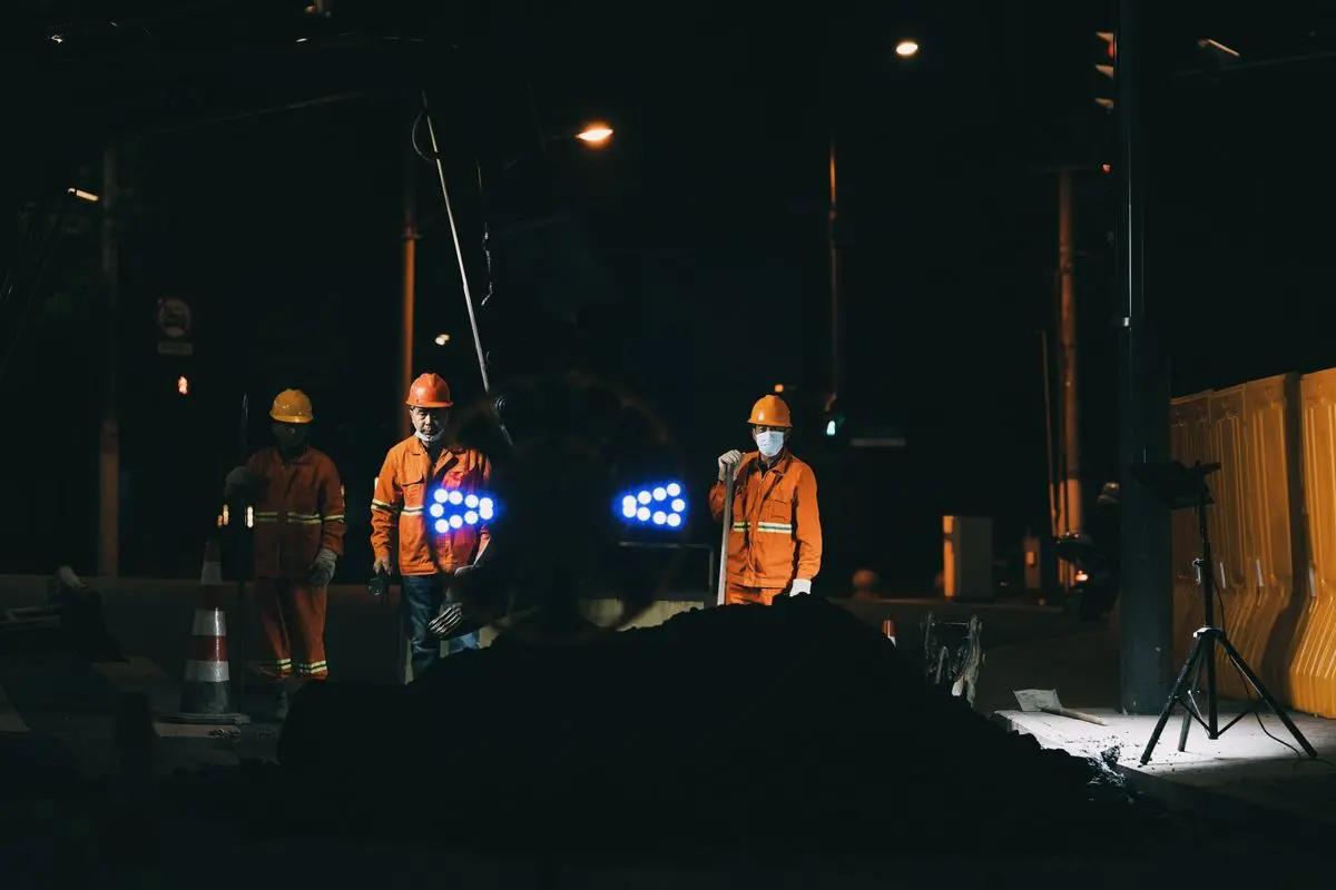Trabalhadores com uniforme de alta visibilidade refletivo e capacete em obra — exemplo de uniforme que também é EPI